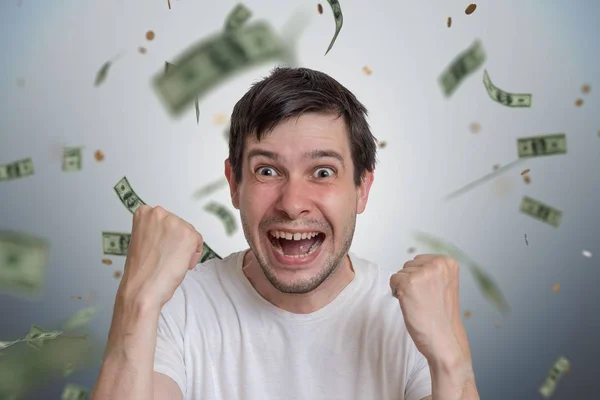 Giovane uomo felice è vincitore della lotteria. I soldi stanno cadendo dall'alto — Foto Stock