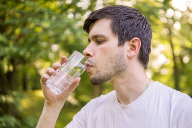 İçme suyu bardaktan güneşli sıcak da, doğada genç adamdır