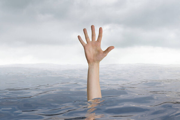 Man is drowning in ocean. Only hand is visible.