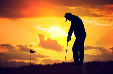 Günbatımında golf oynayan adam silüeti.