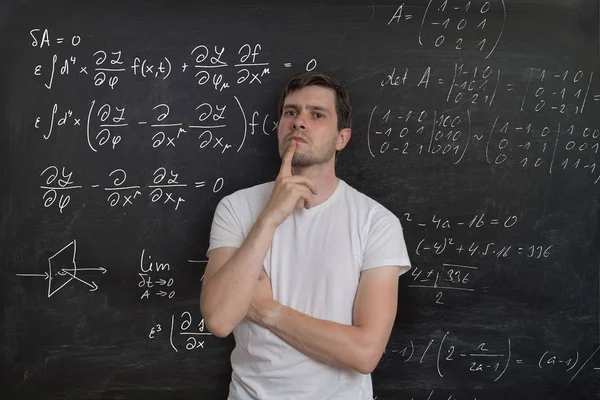 Un joven estudiante está pensando y resolviendo problemas matemáticos. Matemáticas —  Fotos de Stock