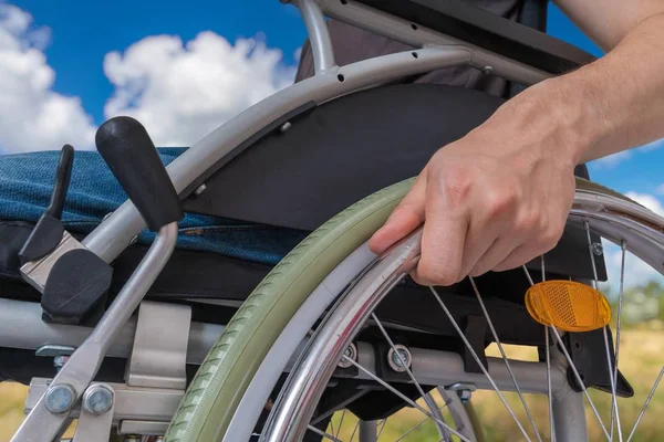 Deficiente deficiente homem sentado em cadeira de rodas ao ar livre no meado — Fotografia de Stock