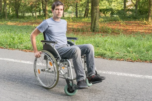 Νέοι αναπήρων ή απενεργοποιημένη άνδρα σε αναπηρικό καροτσάκι. — Φωτογραφία Αρχείου