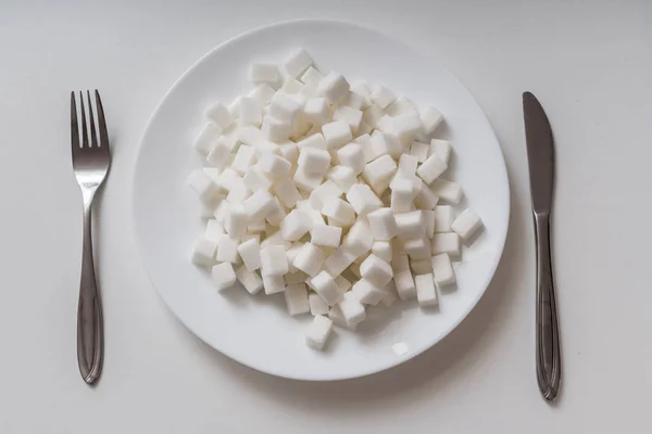 Vista superior no prato cheio de cubec de açúcar. Conceito de alimentação não saudável . — Fotografia de Stock