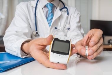 Doktor diyabetik hasta için kan ölçmek için şeker ölçüm veriyor