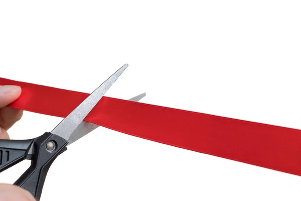 Scissors are cutting red ribbon or tape. Isolated on white backg — Stock Photo, Image