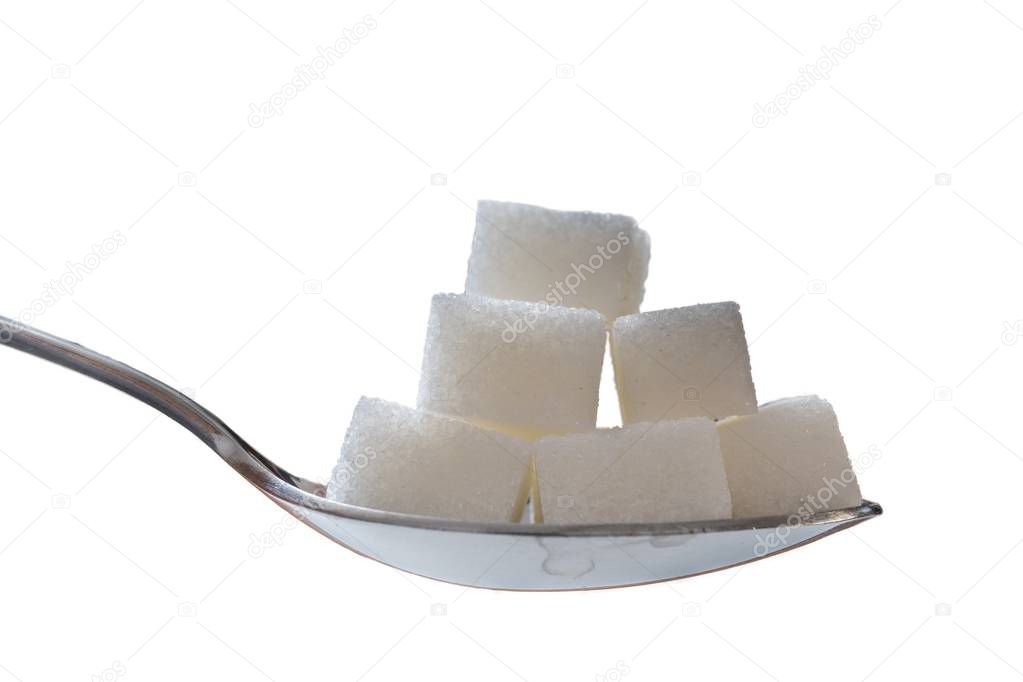 Close up view on spoon with many sugar cubes. Isolated on white 