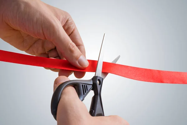 Man handen zijn snijden rood lint met een schaar. Openingsavond. — Stockfoto