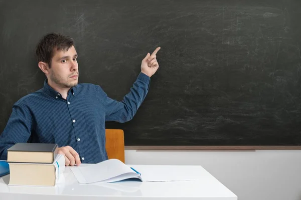 Guru muda menunjuk papan tulis kosong dengan jari . — Stok Foto