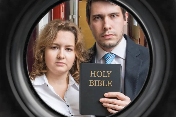 Zeugen Jehovas zeigen die Bibel hinter der Tür. Blick aus dem Fenster — Stockfoto