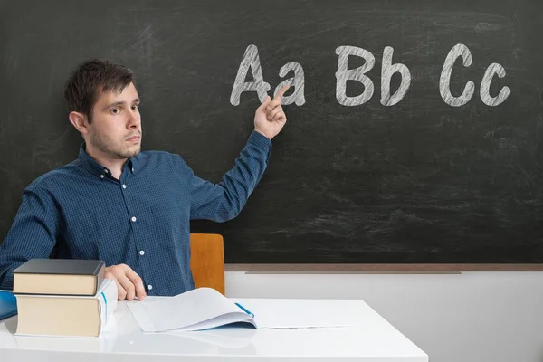 Young teacher is teaching ABC at elementary school. Letters writ — Stock Photo, Image