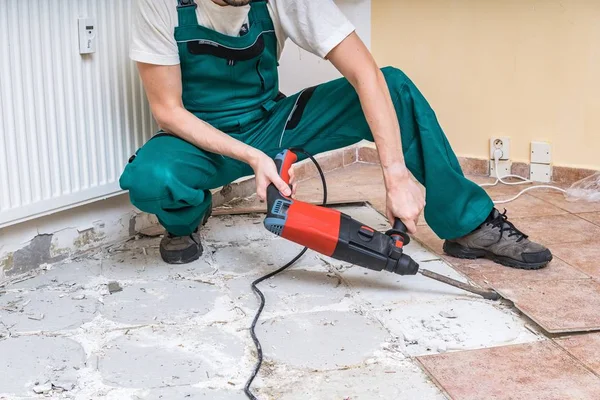 Renovação do piso antigo. Demolição de azulejos antigos com martelo pneumático — Fotografia de Stock