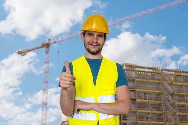 Trabalhador feliz no canteiro de obras está mostrando polegares para cima gesto . — Fotografia de Stock