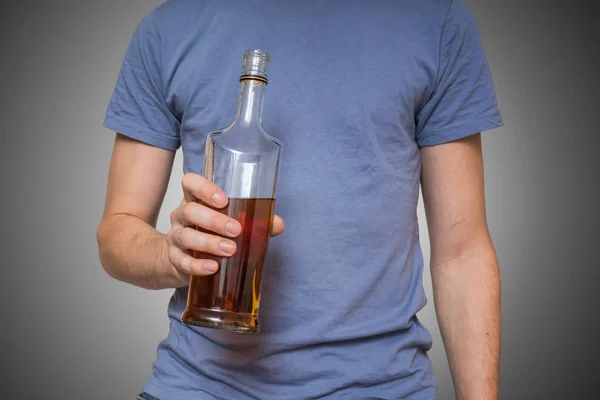 アルコール男性はウイスキーの瓶を保持しています。. — ストック写真
