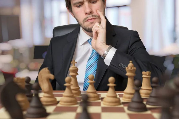 Jeune homme pense et joue aux échecs . — Photo