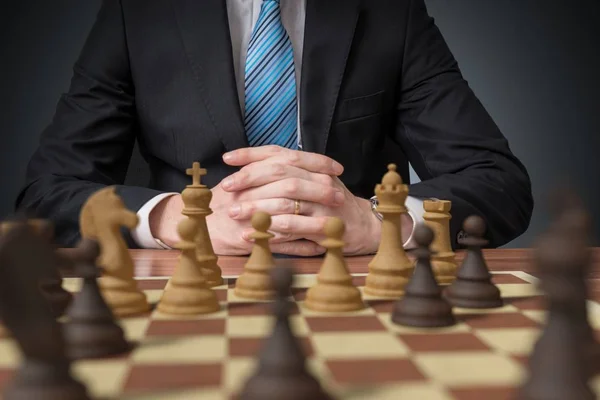 Joven hombre de negocios está pensando y jugando ajedrez . — Foto de Stock