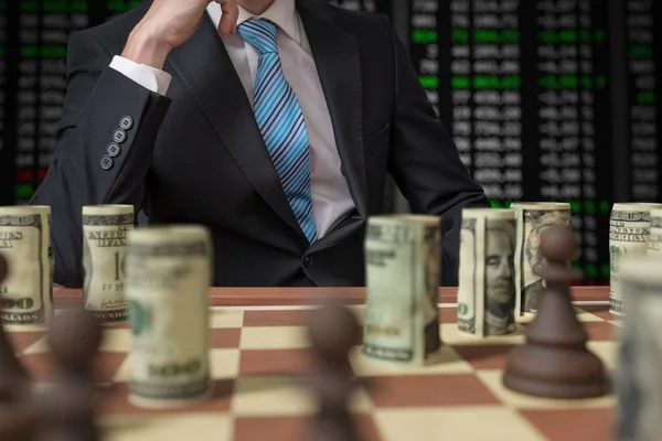 Conceito de estratégia de investimento. Homem está jogando xadrez com dinheiro . — Fotografia de Stock
