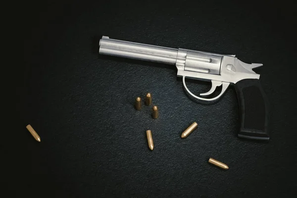 Место преступления. Пистолет с большим количеством пуль на черном кожаном фоне . — стоковое фото