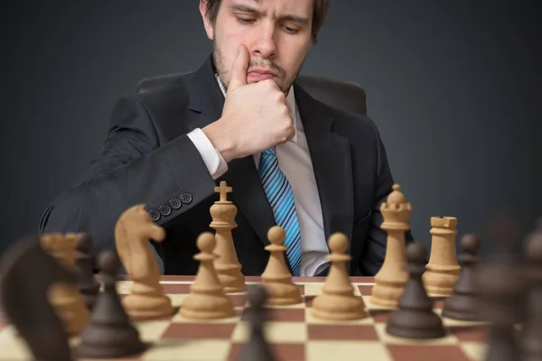 Jovem empresário está pensando e jogando xadrez . — Fotografia de Stock