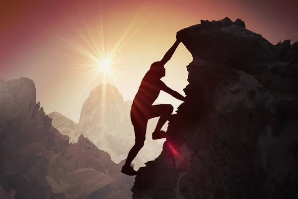 Silhouet van een jonge man klimmen op berg. — Stockfoto