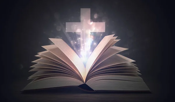 Christianity concept. Open shining holy bible and cross above. — Stock Photo, Image