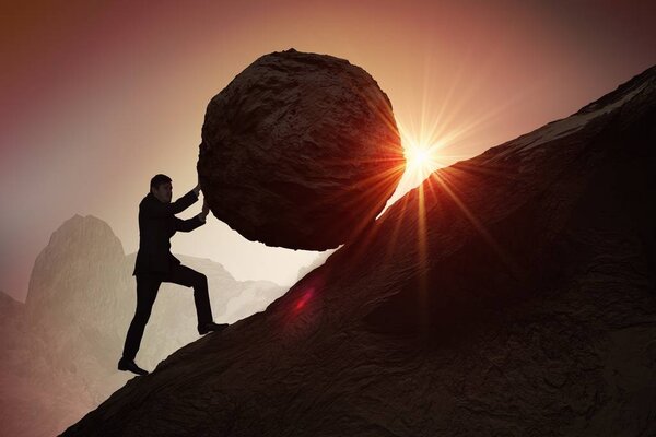 Sisyphus metaphore. Silhouette of businessman pushing heavy ston
