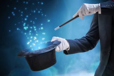 Sihirbaz veya Illusionist büyü hüner gösteriyor. Mavi sahne arka planda ışık.