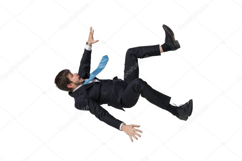 Young businessman falling down in free fall. Isolated on white b