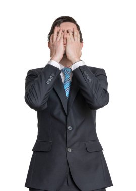 Disappointed man is covering his face with hands. Isolated on wh clipart