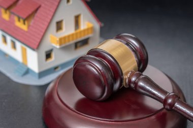 Evin açık artırma kavram. Bir ev modeli önünde tokmak.