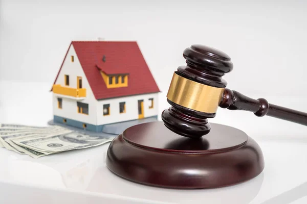 House auction concept. Gavel in front of model of house. — Stock Photo, Image