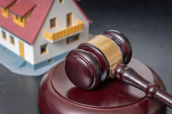 Conceito de leilão. Gavel na frente de um modelo de casa . — Fotografia de Stock