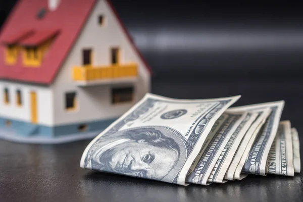 Cobertura hipotecária. Dinheiro na frente de uma casa . — Fotografia de Stock