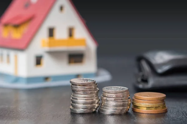 Cobertura hipotecária. Dinheiro e moedas na frente de uma casa . — Fotografia de Stock