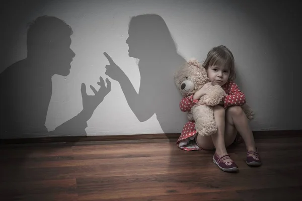 Concepto de divorcio. Niño triste está sentado en el suelo cuando los padres argu — Foto de Stock