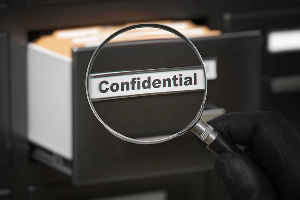 Hombre con lupa mirando archivos secretos confidenciales . — Foto de Stock