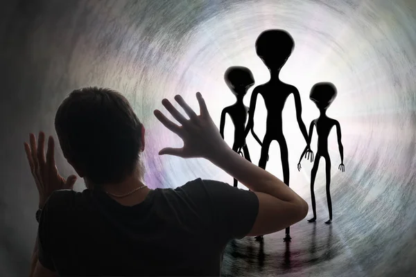 Man is scared of silhouettes of aliens in tunnel. Abduction and — 스톡 사진