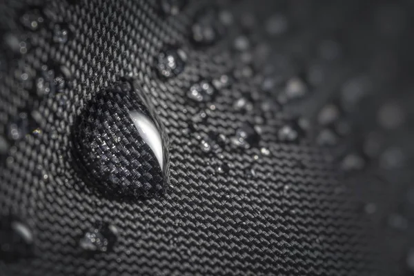 Gota de água em tecido impermeável impregnado de guarda-chuva preto du — Fotografia de Stock