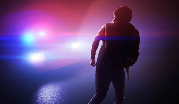Silhouette of young man - thief escaping from police car at nigh — Stock Photo, Image