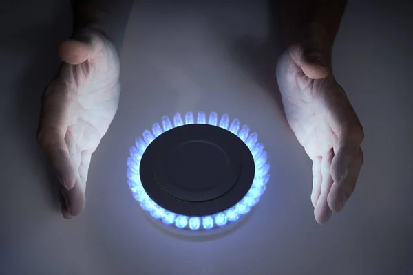 Man is warming hands near blue propane butane gas on stove. — Stock Photo, Image