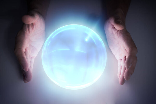 Magician or fortune teller is predicting future with crystal sph