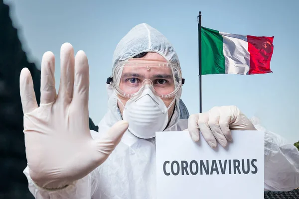 Doctor in coveralls warns of coronavirus infection in Italy. Italian flag in background.