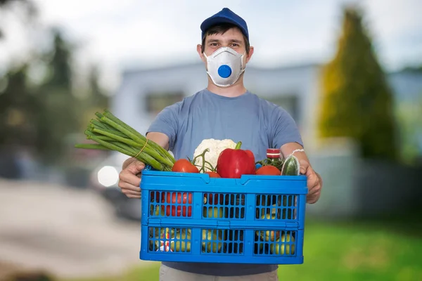 Ffp3マスクを持つ男は ウイルスの流行中に食品や食料品を提供しています — ストック写真