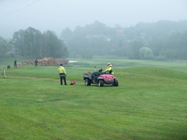 bir golf sahası üzerinde çalışıyor 