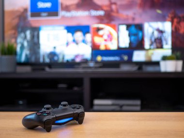 Uk, Jan 2020: Playstation 4 için Sony dualshock 4 kumanda kumandası ve arkasında TV ekranı