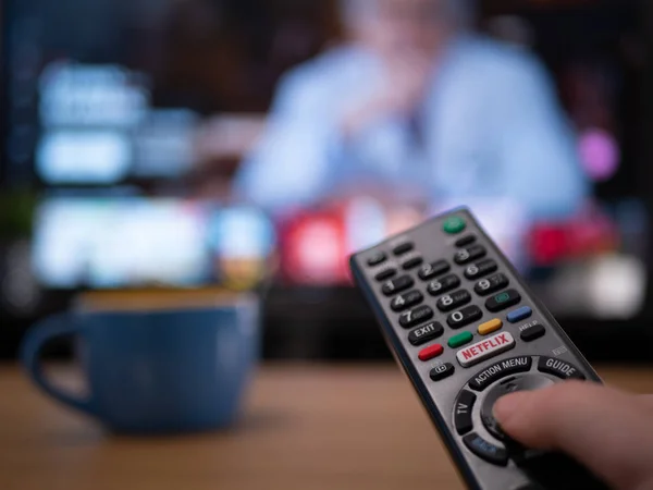 Uk, Jan 2020: Netflix menüsünü gösteren televizyonun arkasındaki uzaktan kumandayı kapat