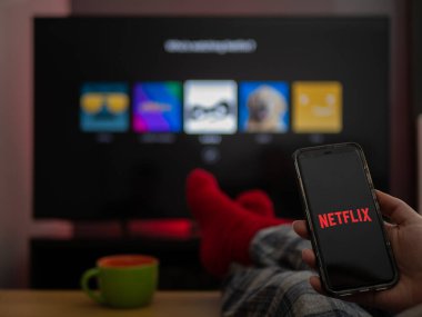 İngiltere, Mart 2020: TV Televizyon Netflix 'te telefon ve TV' de ayaklar rahat