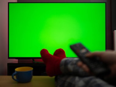 Televizyon krom anahtar yeşil ekran. Uzaktan kumandalı ayaklar evde.