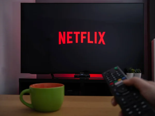 stock image UK, March 2020: TV Television Netflix logo on screen with remote