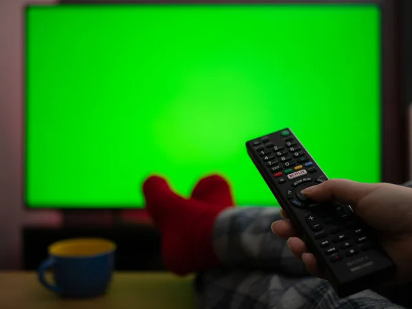 Pijamalarını Giyip Ayaklarının Üzerinde Oturmuş Yeşil Ekran Krom Tuşlu Televizyon — Stok fotoğraf